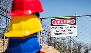 Hard hats in foreground with Danger warning sign in background
